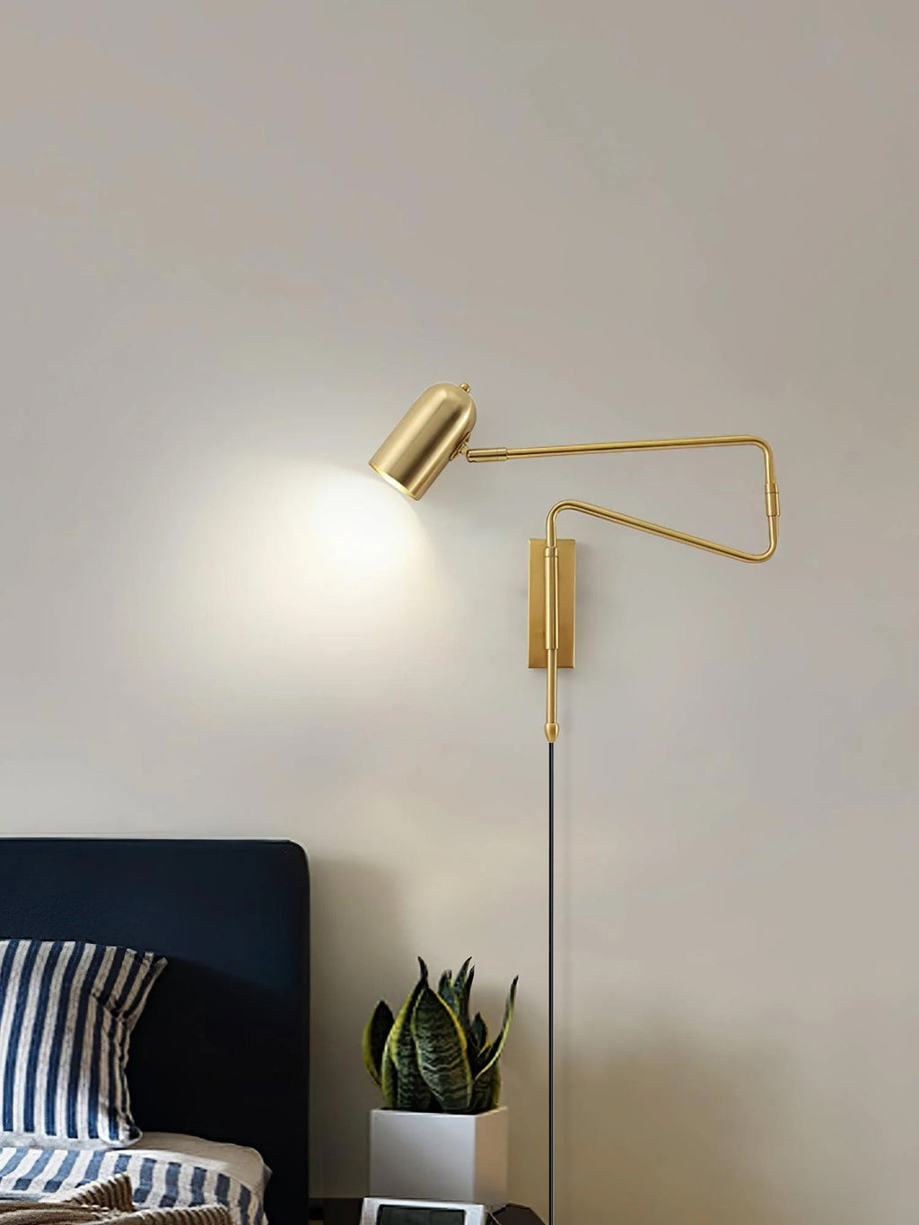 Swing arm wall lamp in a black finish against a pale wall