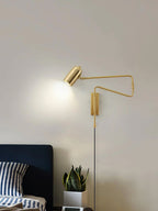 Swing arm wall lamp in a black finish against a pale wall