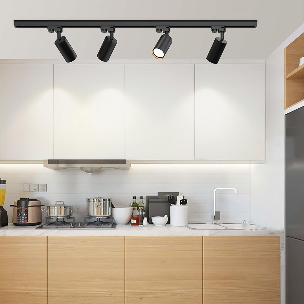 Track ceiling light heads angled toward a headboard accent