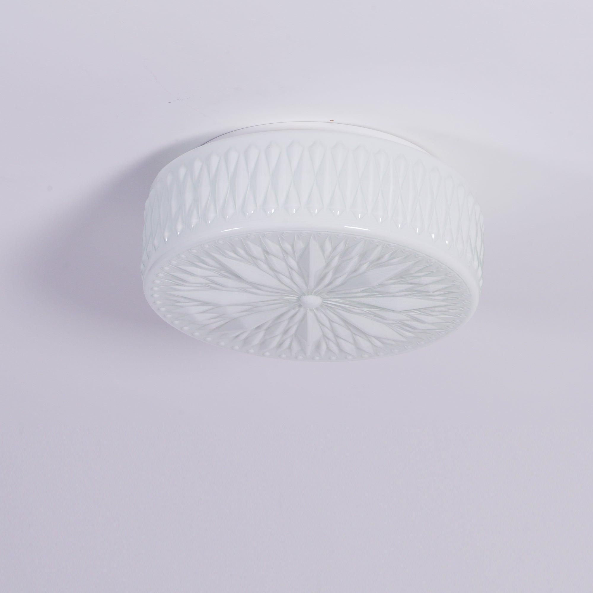 Adler ceiling light glowing evenly in a bedroom