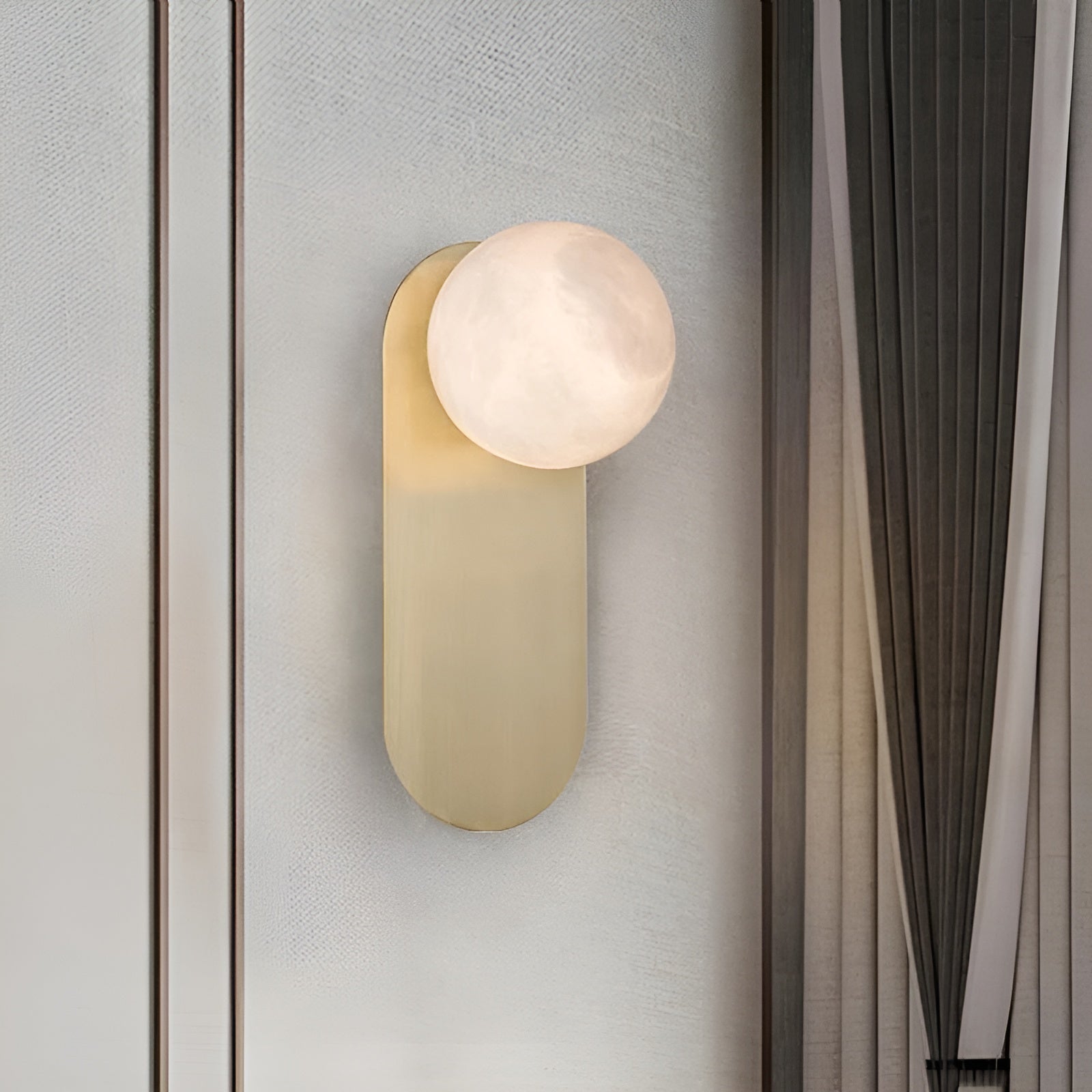 Three-quarter view of the Adela sconce on a pale panelled wall, showing how little it projects from the surface