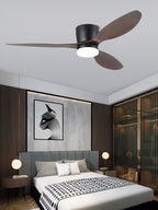This Clérachic ceiling fan glows warm above a bedroom with a dark wood accent wall and framed abstract art.
