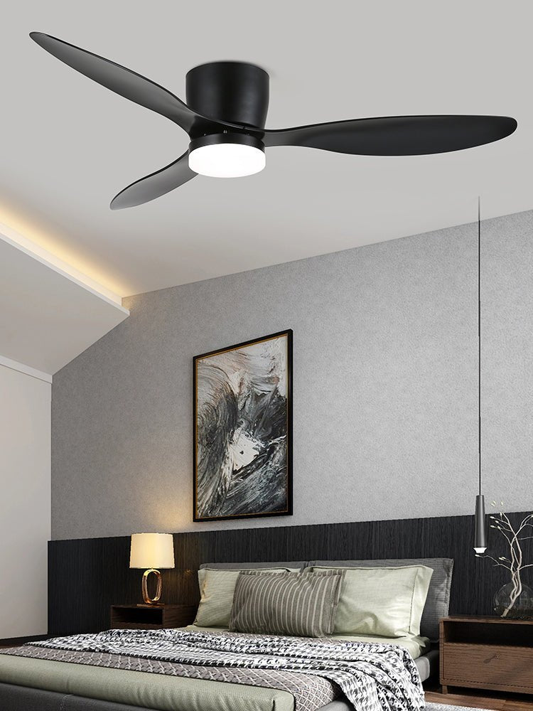 Black blades turn on this Clérachic ceiling fan, glowing warm above a grey bedroom with a slim pendant light.