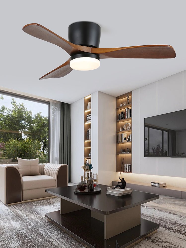 This Clérachic ceiling fan sits above a bright living room with open bookshelves, a television nook and a round coffee table.