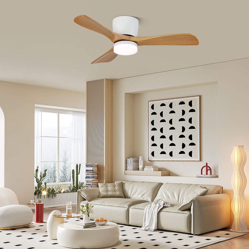 This Clérachic ceiling fan glows warm above a living room with a cream sofa and a floor lamp.