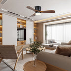 This Clérachic ceiling fan glows warm above a living room with built-in bookshelves and a large window.