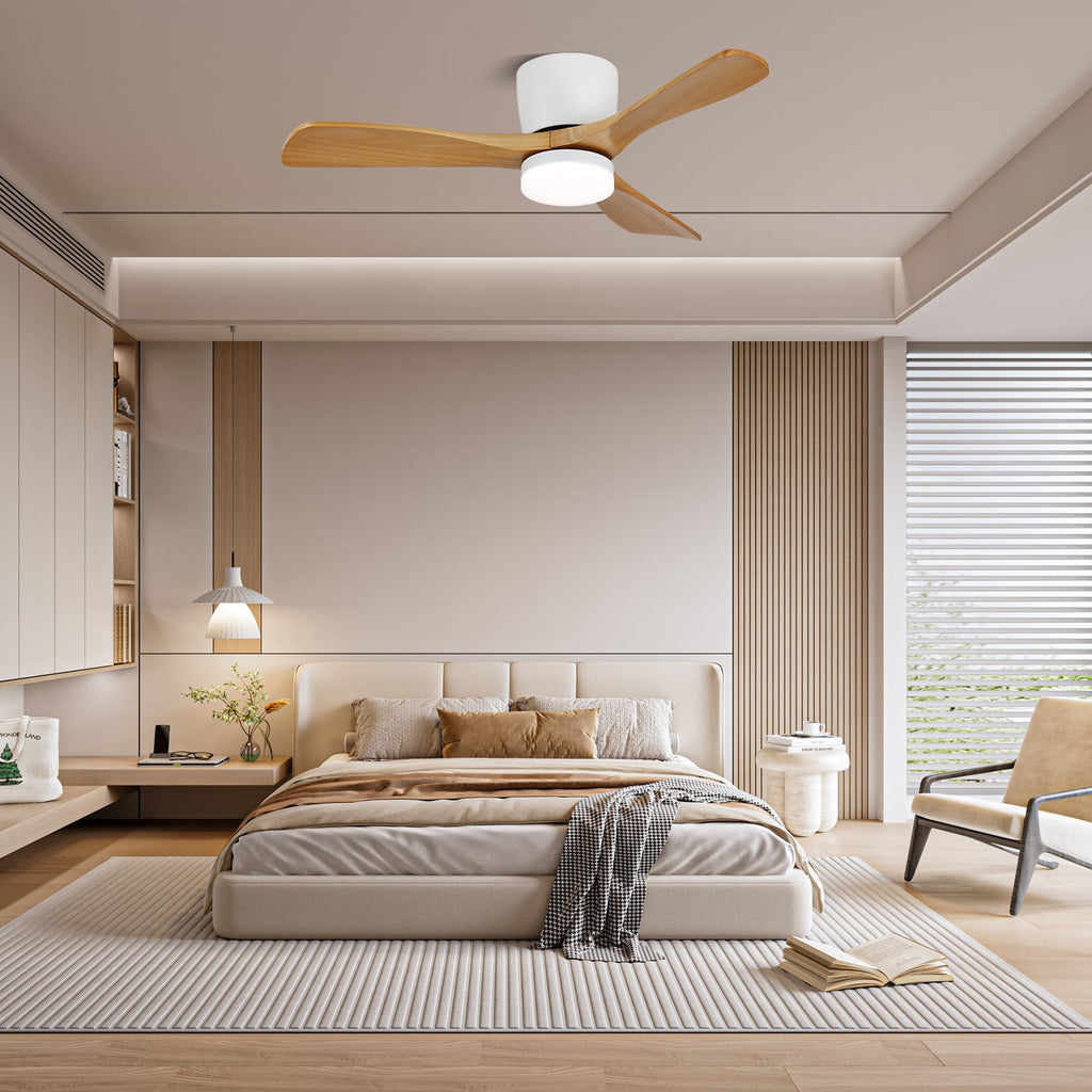 Light wood-grain blades turn on this Clérachic ceiling fan above a bedroom with a slatted wood accent wall.