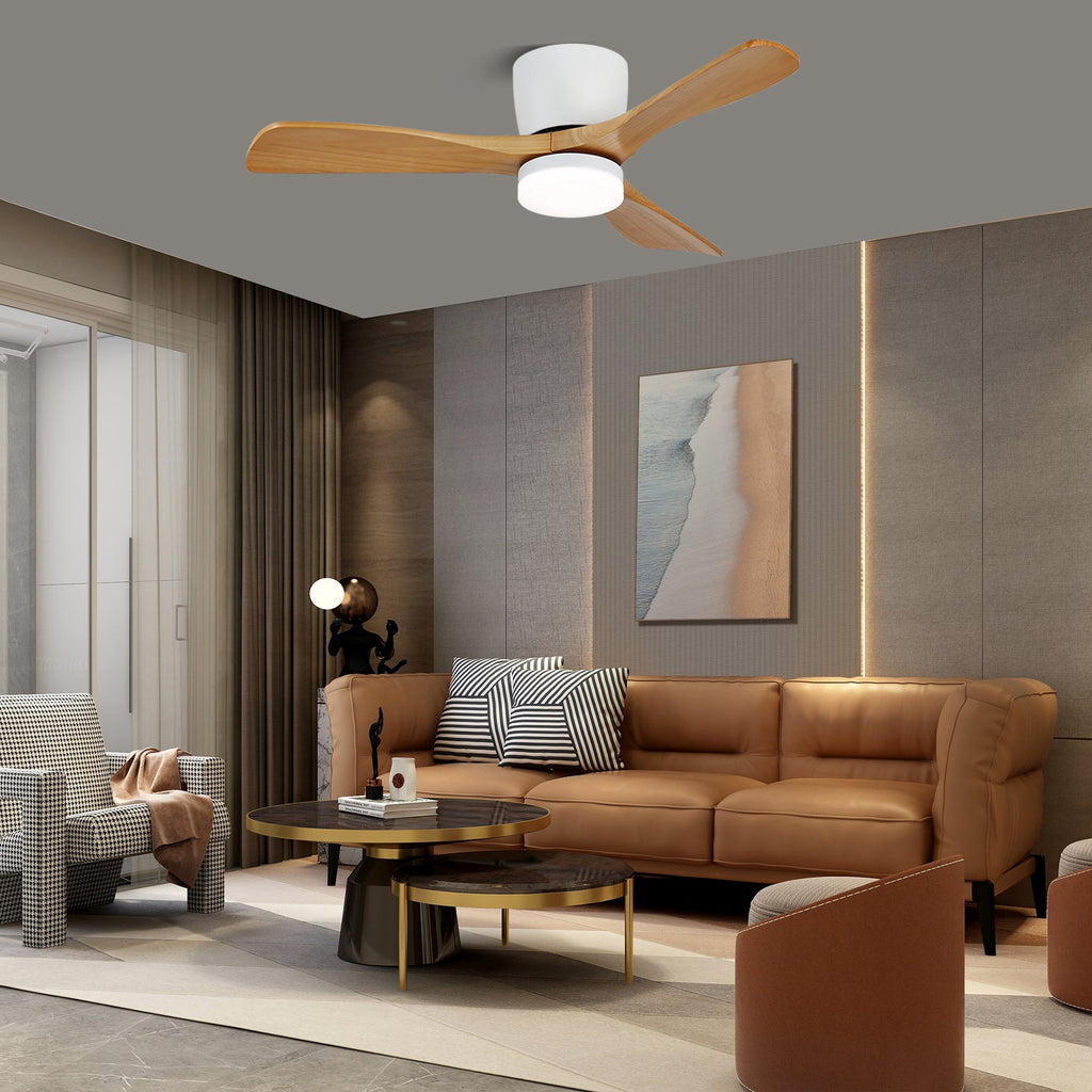 Walnut wood-grain blades and a black motor mark this Clérachic ceiling fan, glowing warm above a grey-walled living room with a leather sofa.