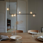 Glass sphere pendant light viewed against a pale wall