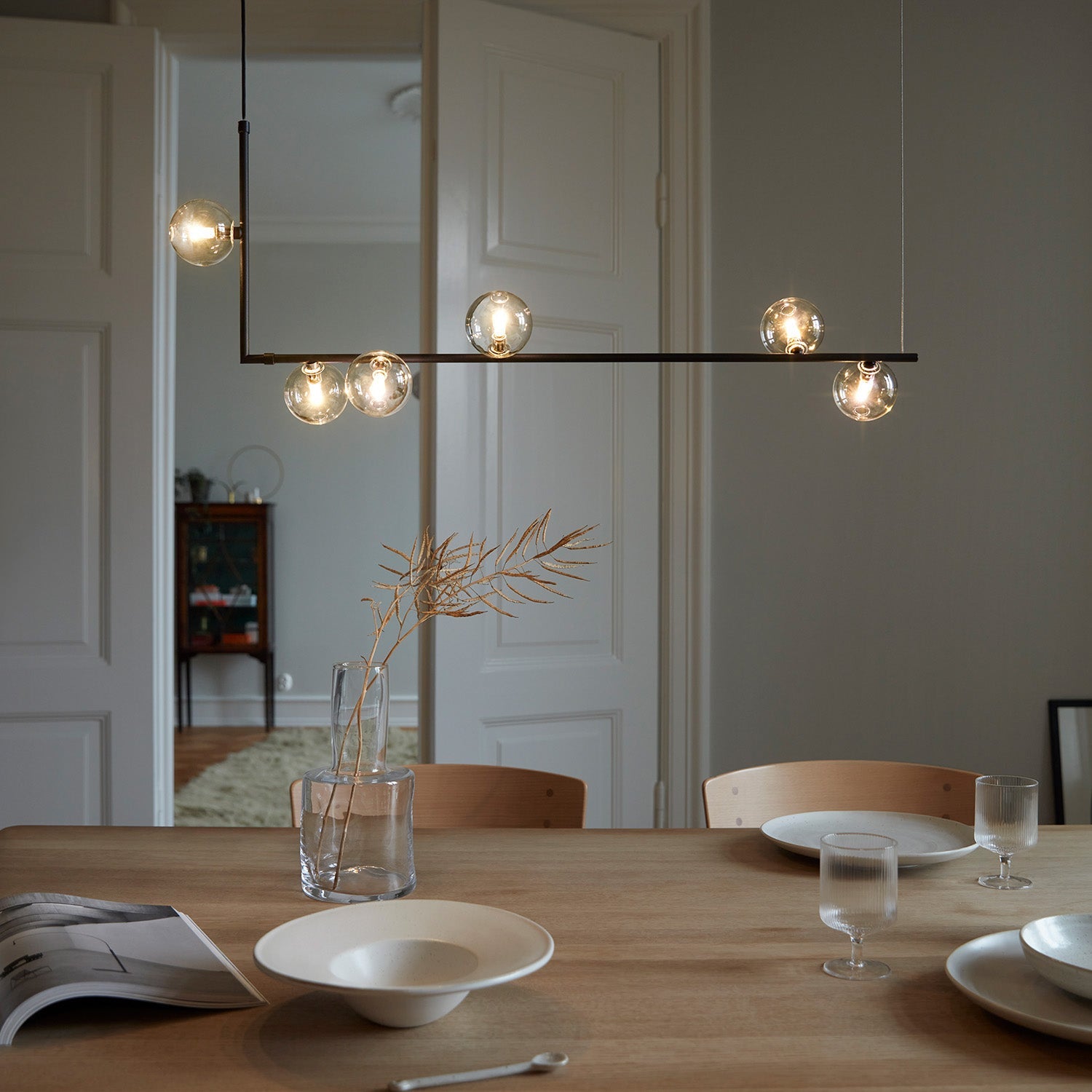 Glass sphere pendant light viewed against a pale wall