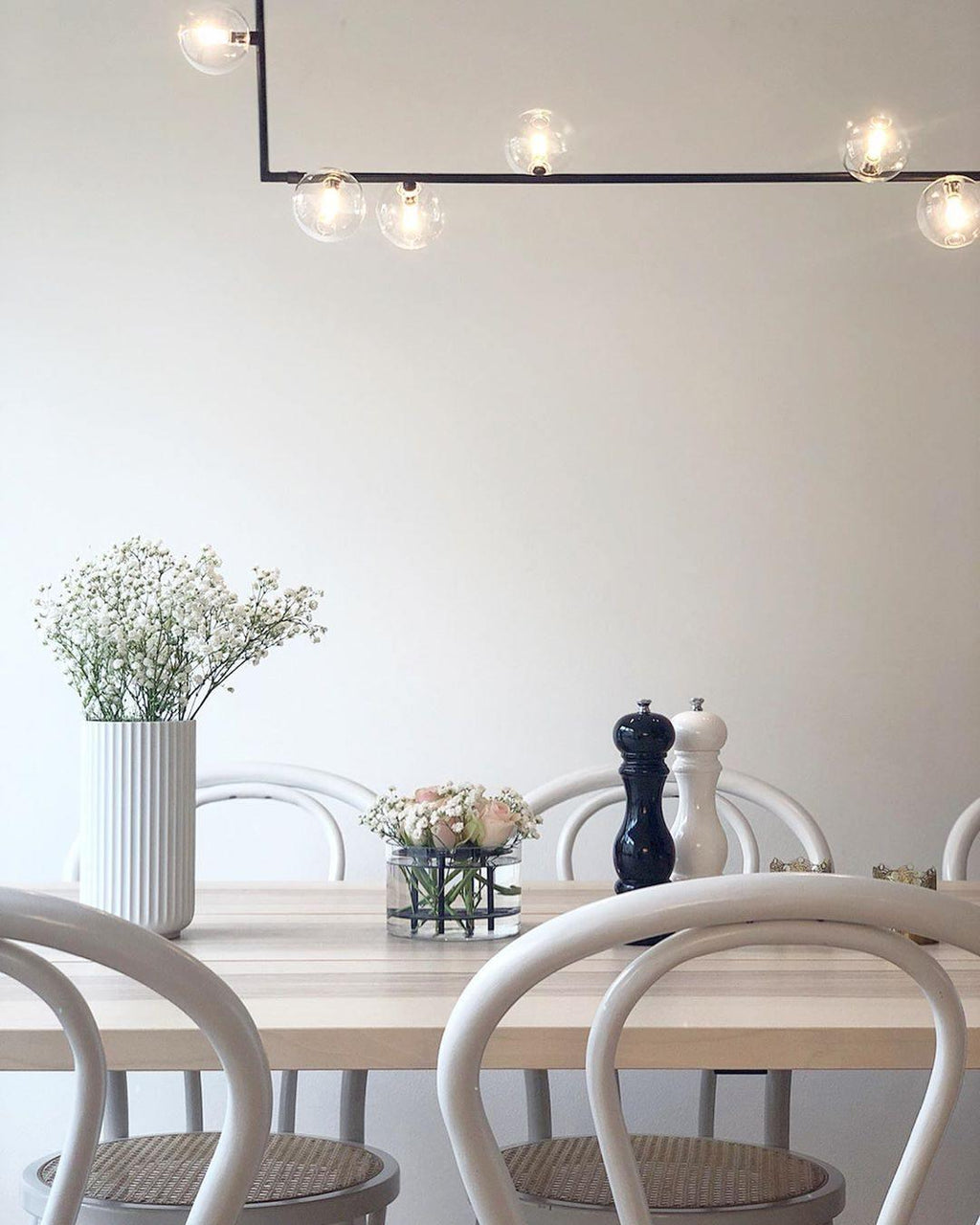 Glass globe pendant light suspended over a styled table