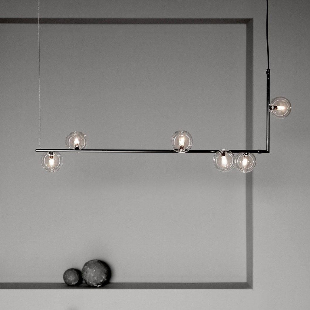 Glass globe pendant light glowing warmly in a styled room