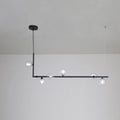 Clear glass sphere pendant light glowing above a dining table