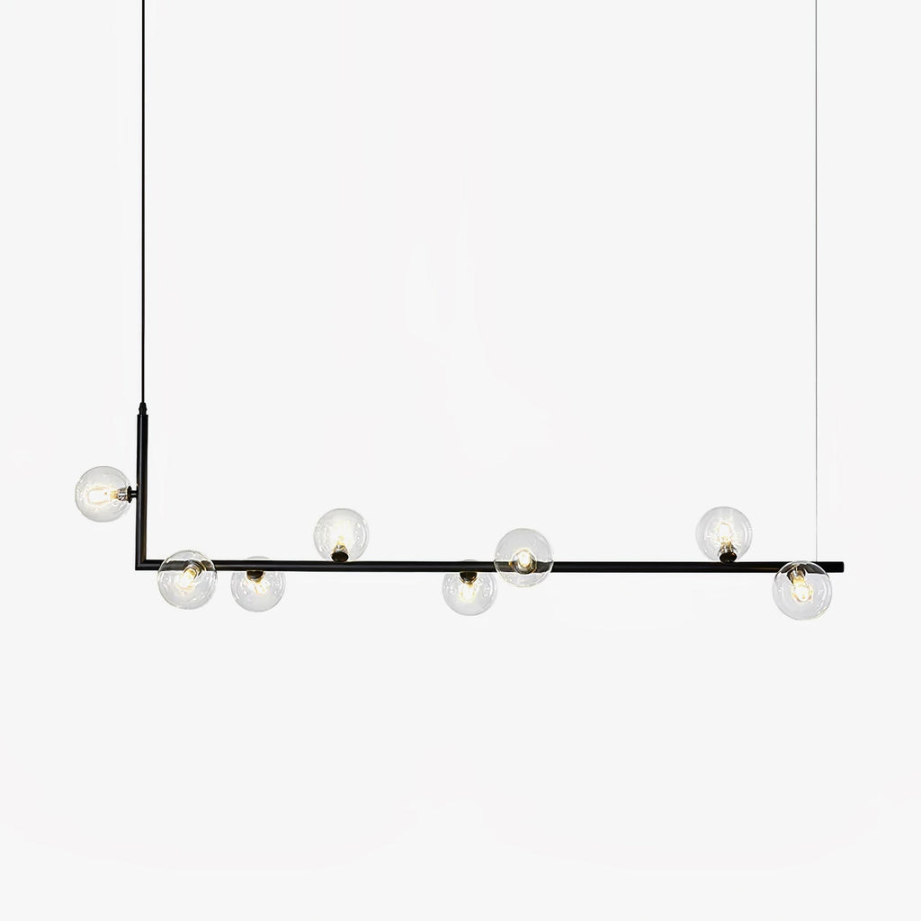 Glass globe pendant light hanging over a long table setting