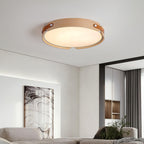 Round wood-finish ceiling light lit in a bedroom setting