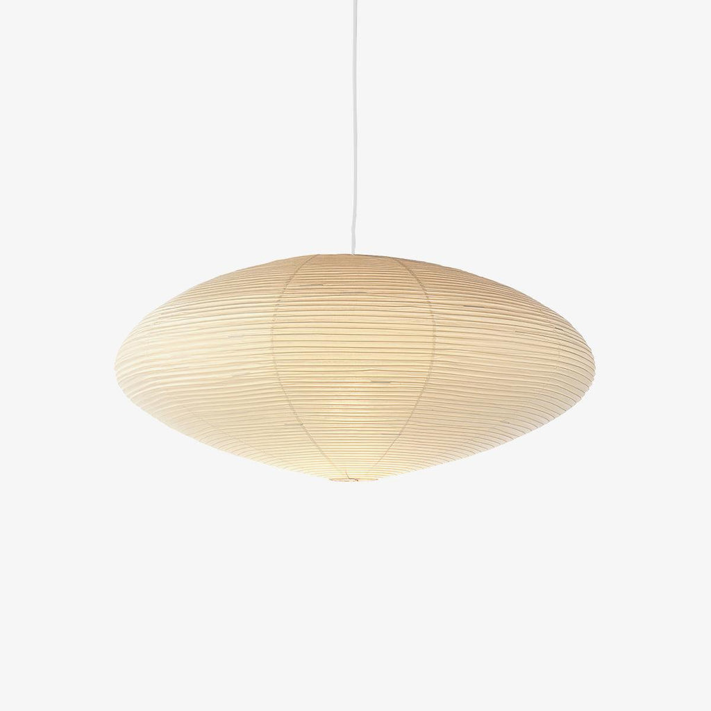 Single washi paper pendant light glowing in a quiet space