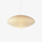 Single washi paper pendant light glowing in a quiet space