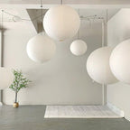 White paper sphere pendant light suspended in a room