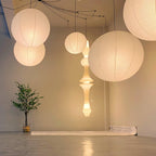 Paper globe pendant light on a black swag cord detail