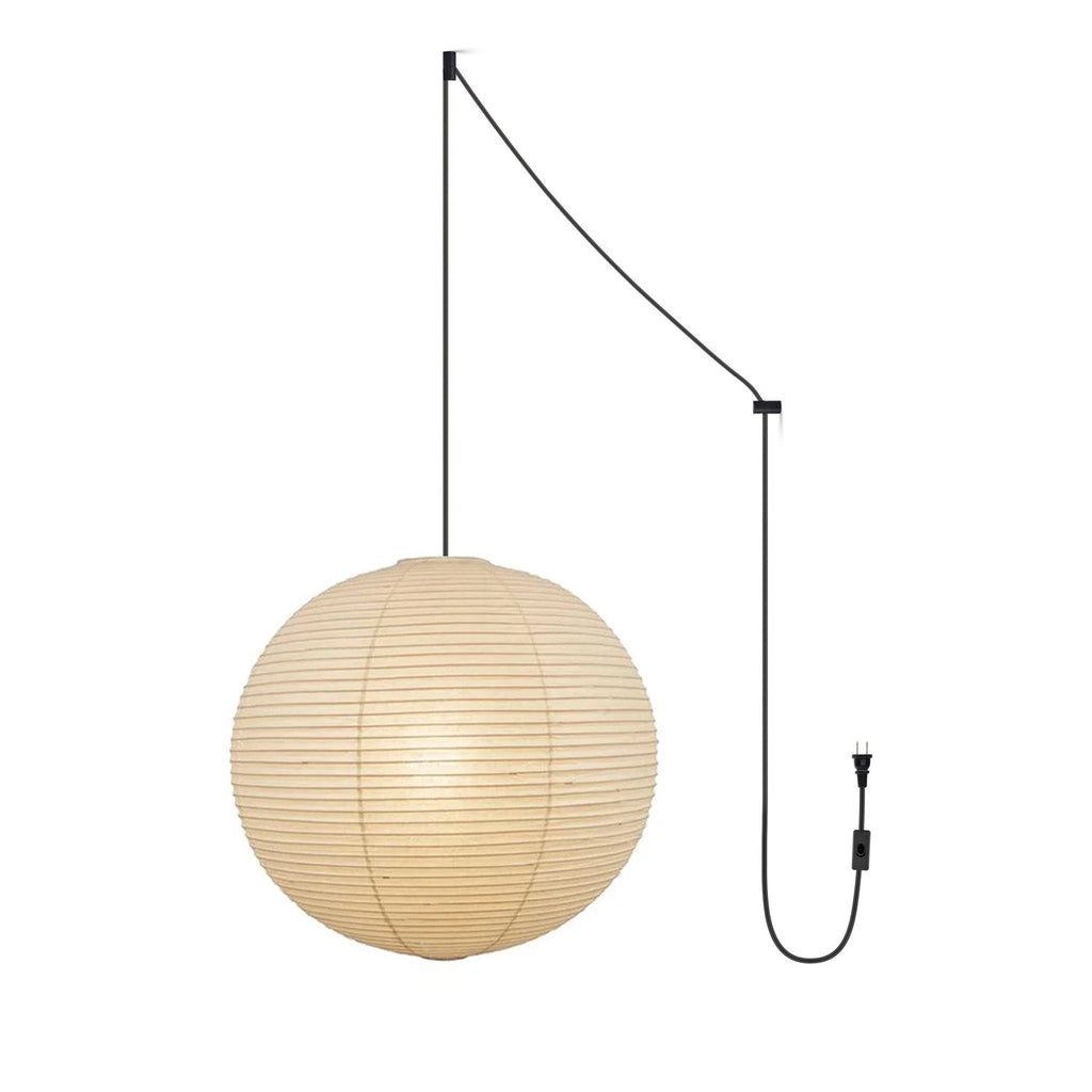 Round mulberry paper pendant light lit warmly in a room