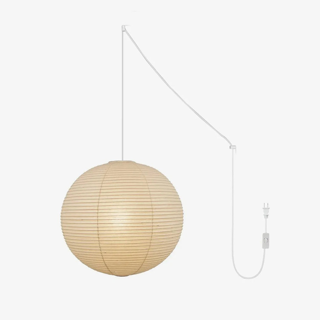 Round mulberry paper pendant light lit warmly in a room