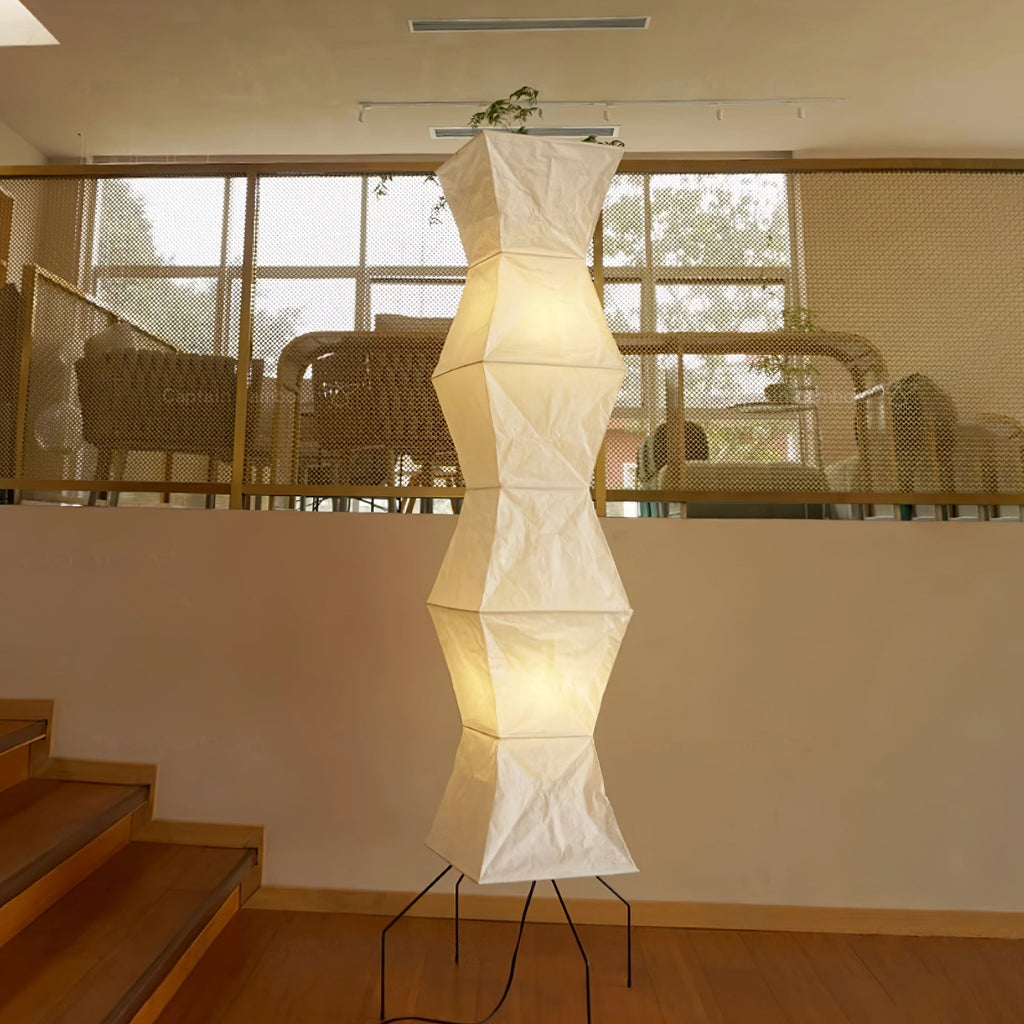 Tall white paper floor lamp casting gentle diffused light