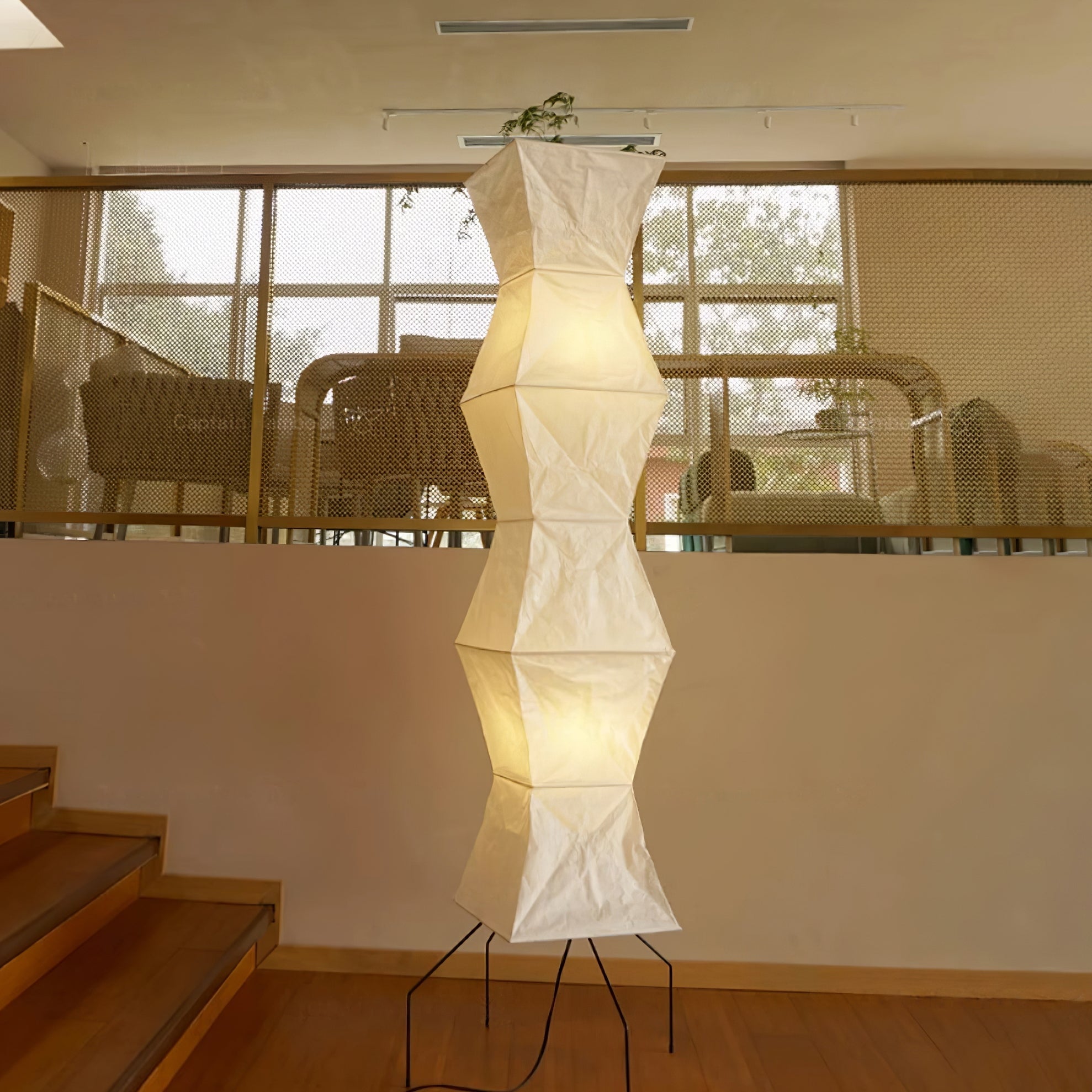 Tall white paper floor lamp casting gentle diffused light