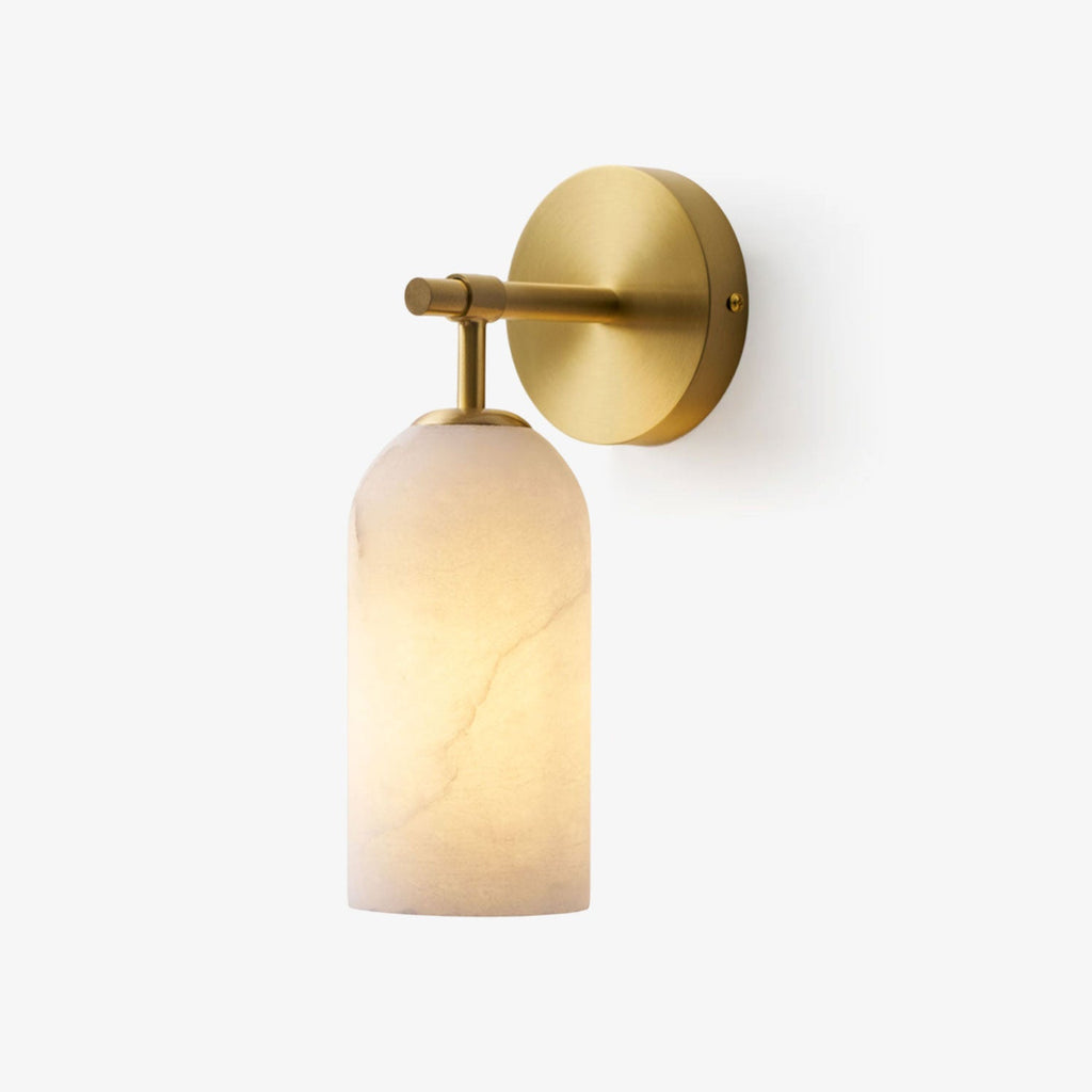 Glowing alabaster cylinder sconce beside a neutral interior wall