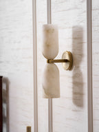 Alabaster wall sconce with copper finish glowing in a room
