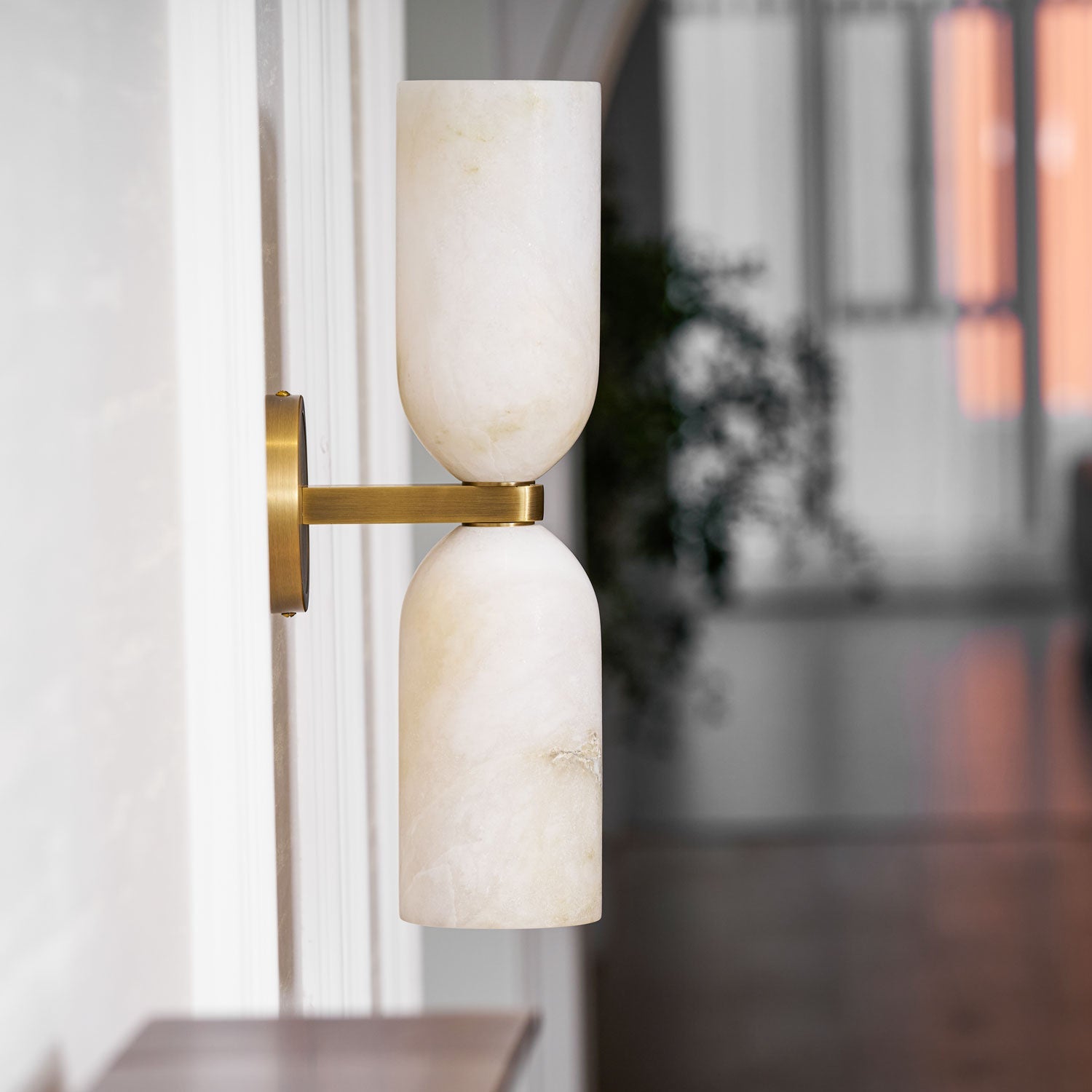 Natural alabaster columns joined by a bronze band with warm light