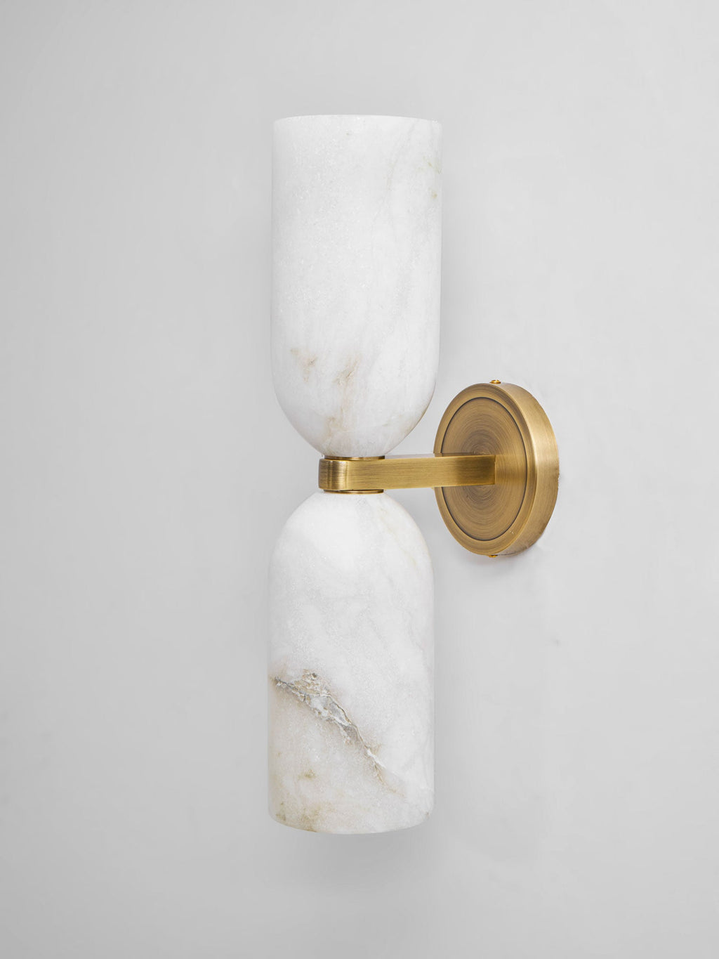 Twin alabaster column wall light showing translucent stone glow