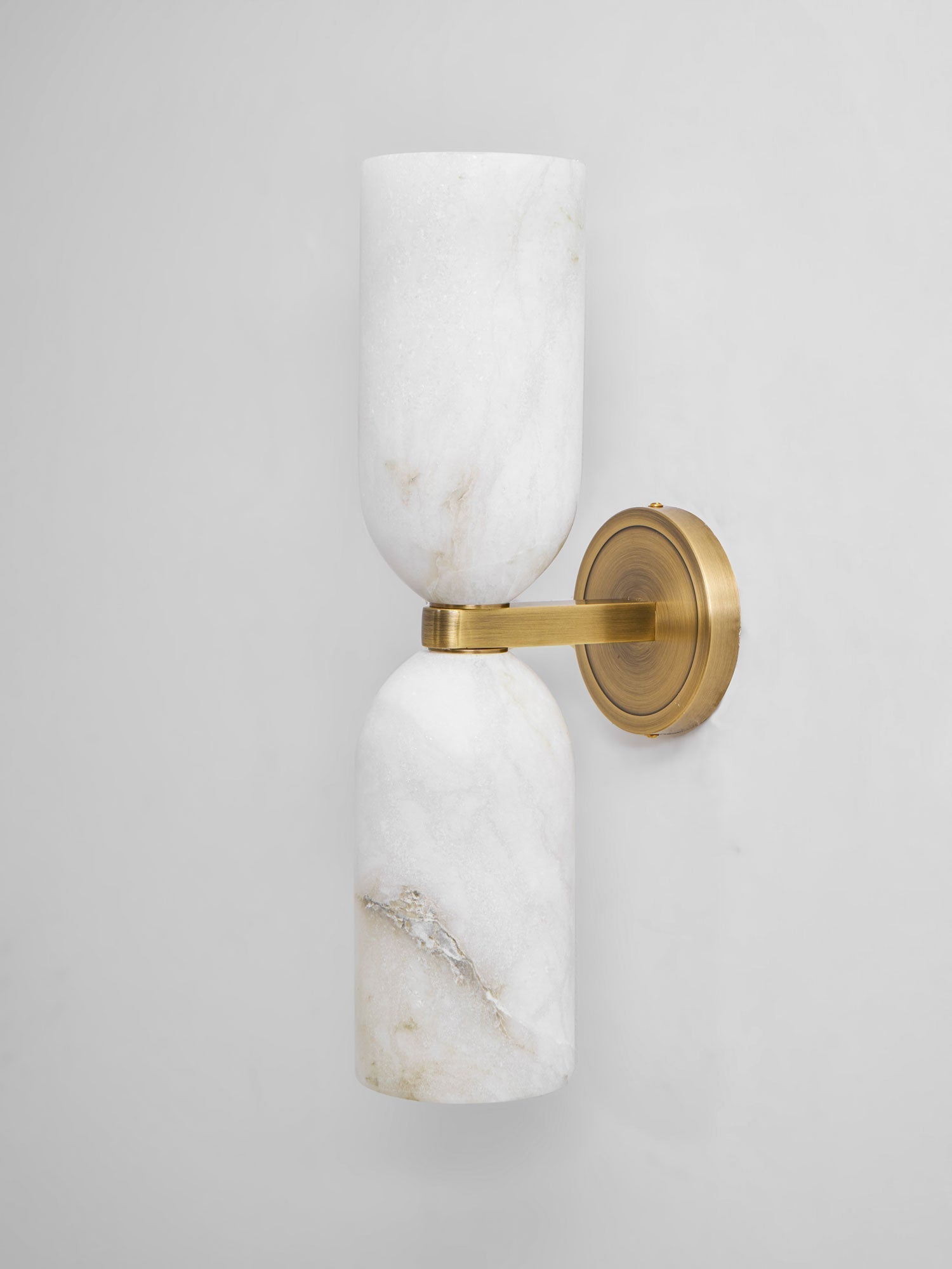 Unlit Nexus Modern Alabaster Wall Light in profile on grey, both shades and the wall plate in view.