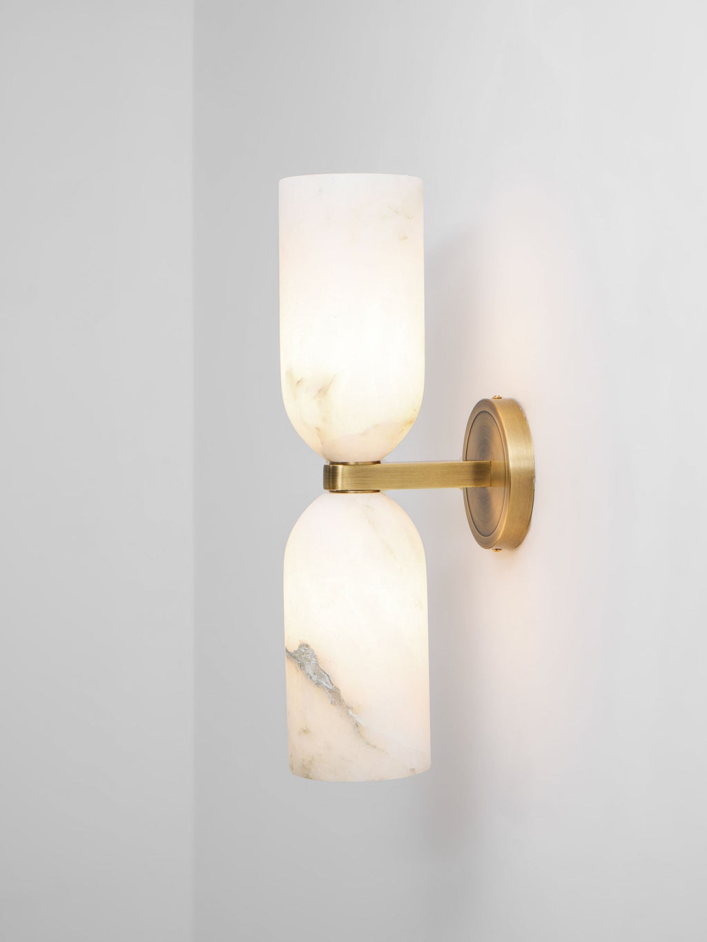 Unlit Nexus Modern Alabaster Wall Light mounted near a wall corner, seen from three quarters.
