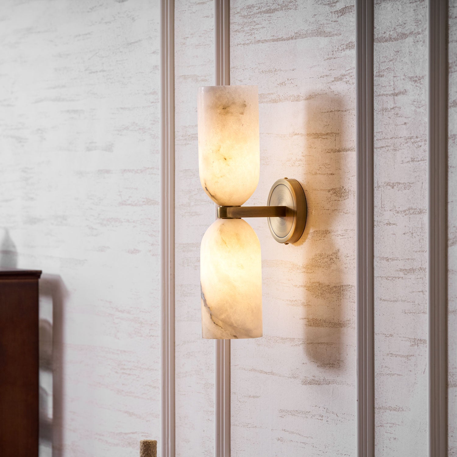 Symmetrical alabaster columns lighting a calm interior corner