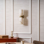 The unlit Nexus Modern Alabaster Wall Light on a panelled wall, stone veining visible in daylight.