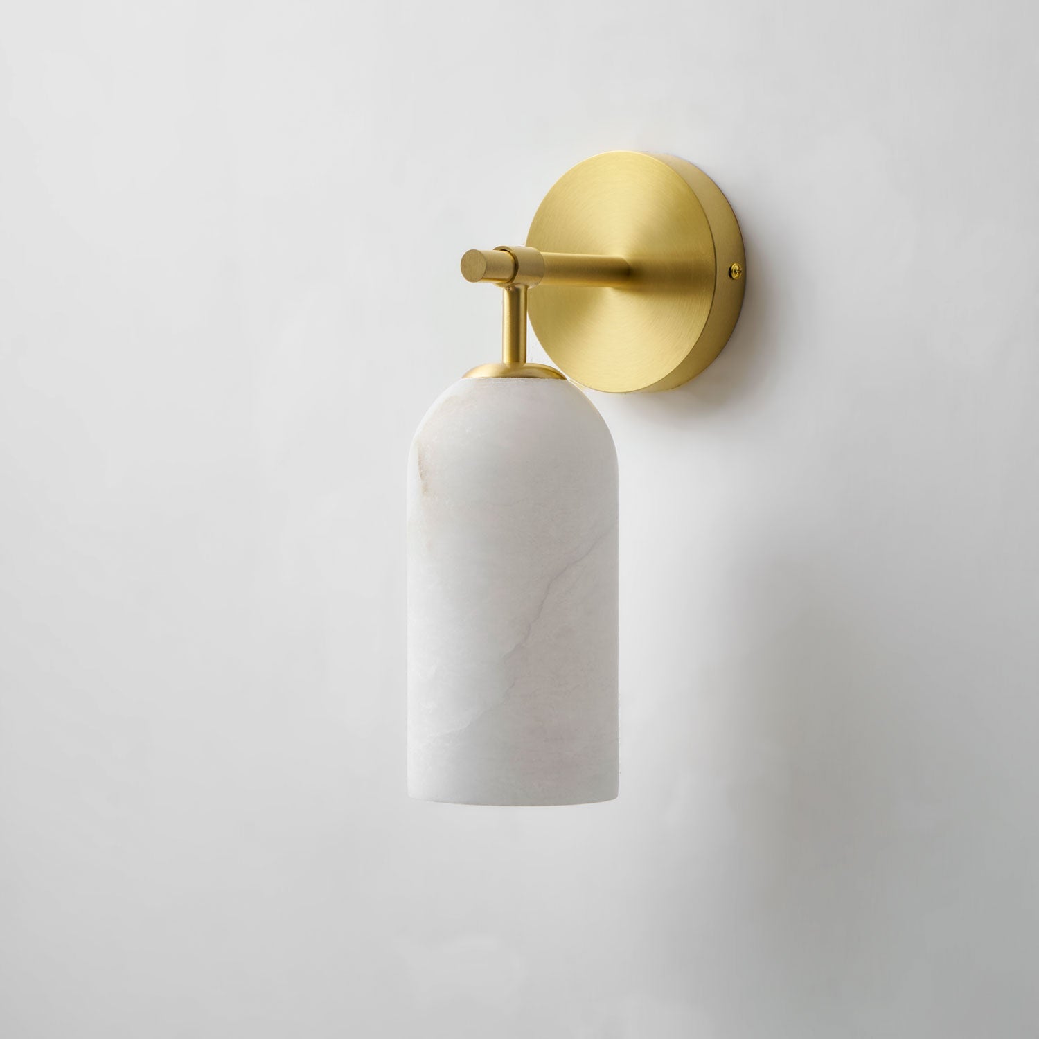Alabaster cylinder wall light with gold finish and gentle glow