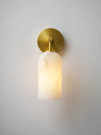 Alabaster pillar wall light in gold and white with warm glow