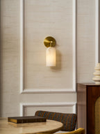 Translucent alabaster cylinder sconce on a slim brushed gold arm