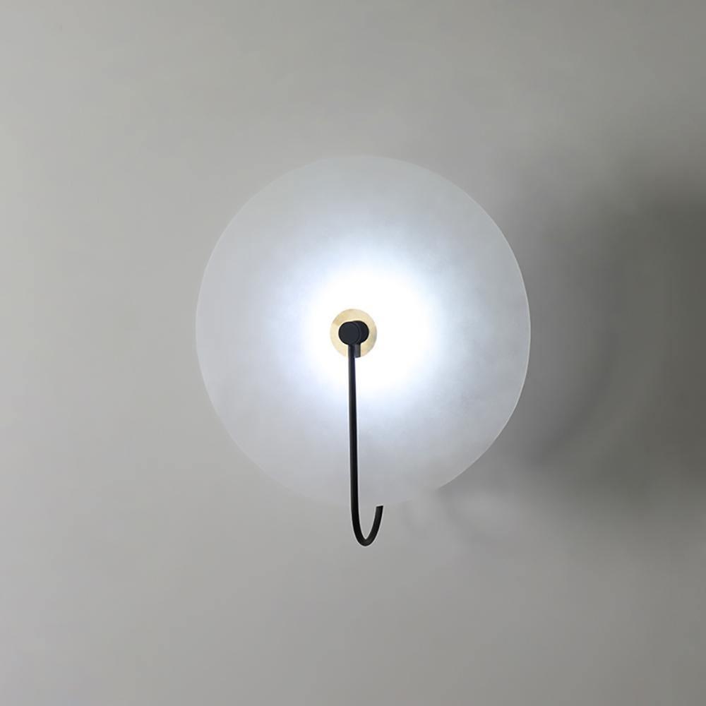 The same Kristy wall lamp with the cold-light bulb, giving a crisp white glow through the alabaster.