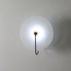 Elaris wall light shown with cool white light, the black hook arm set against a grey wall.