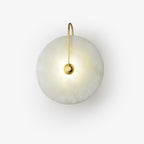 Product view of the lit gold Elaris wall light on white, arm arching down to the central mount.