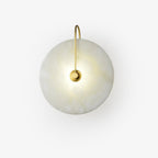 Lit gold Elaris wall light on a plain white background, the disc mottled with natural stone pattern.
