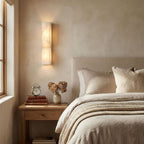 Sculptural carved alabaster wall light glowing in a refined room