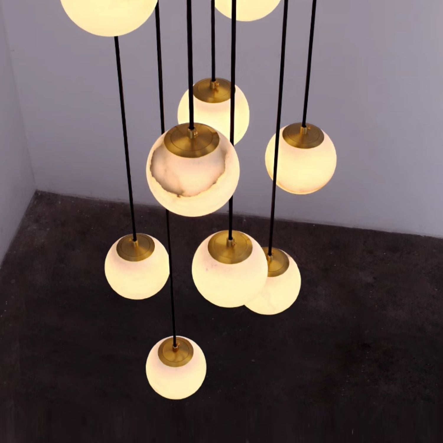 Alabaster balls seen from above in a bare concrete room, brass caps and warm glow visible.