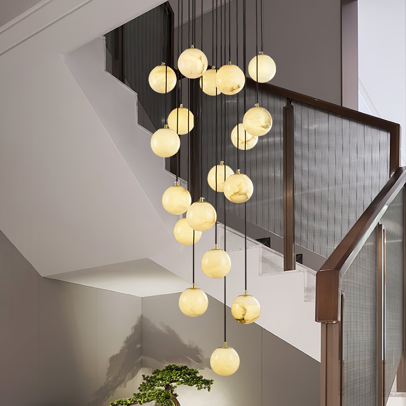The cluster in a stairwell seen from the landing, its lowest ball just above a bonsai.