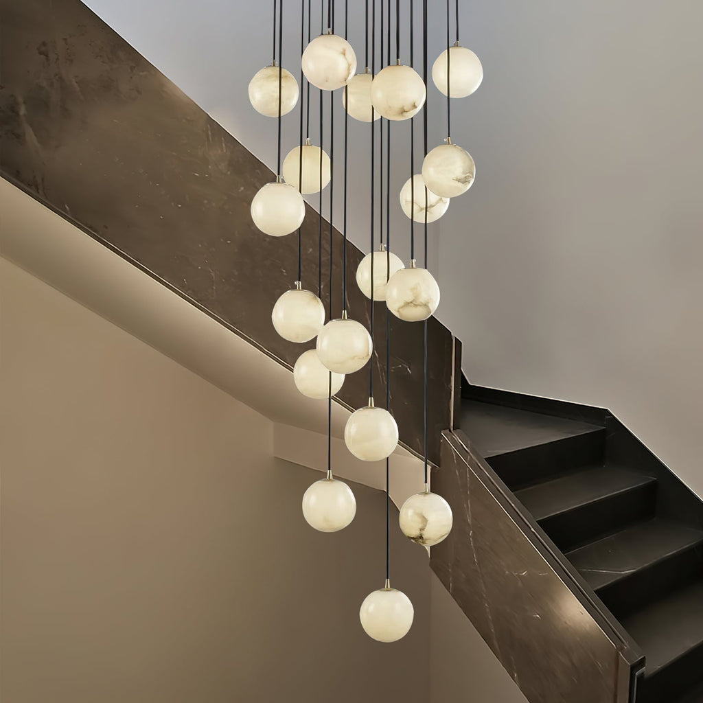 Alabaster ball cluster hanging beside a dark marble staircase, spheres glowing softly.