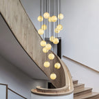 Afralia alabaster cluster chandelier lit above a curved oak staircase, balls glowing warm.
