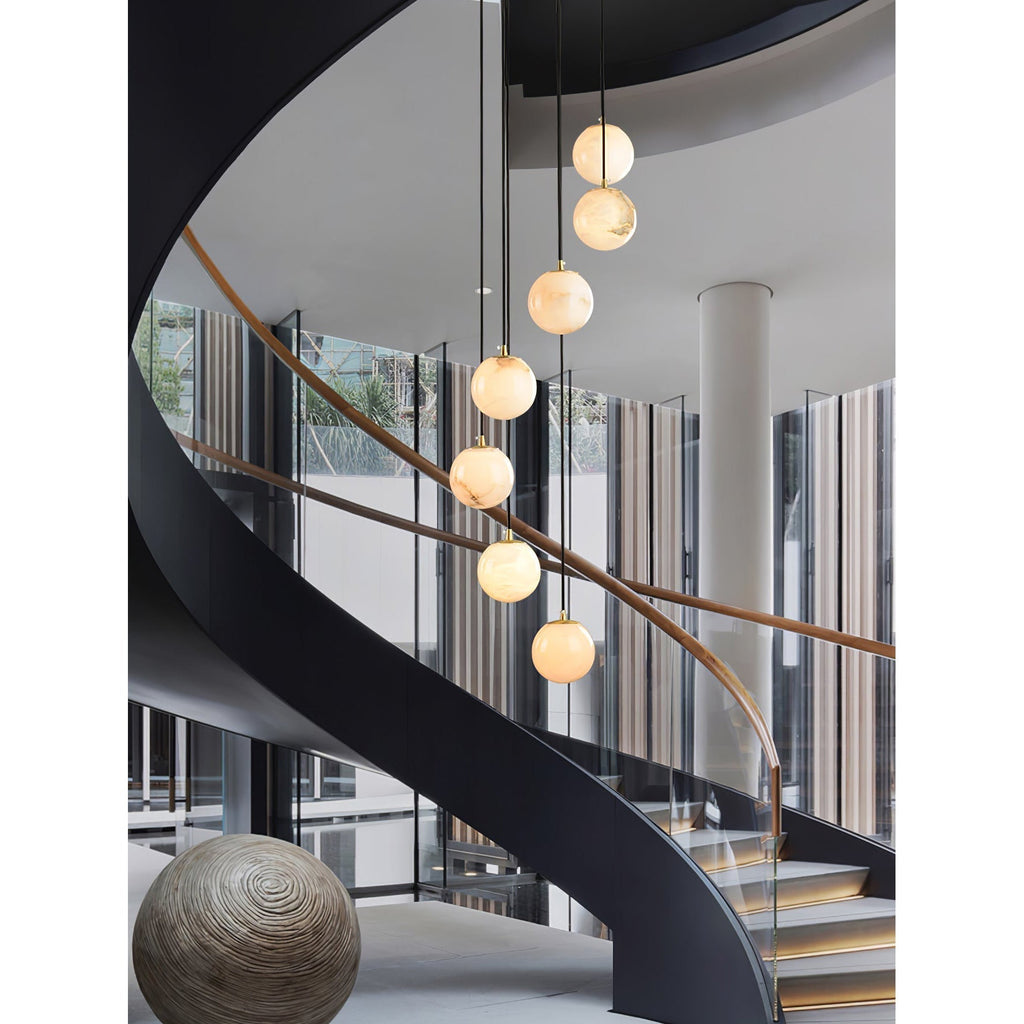 A short run of alabaster balls beside a black steel spiral stair and glazed wall.