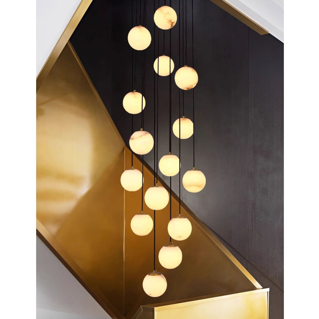 The alabaster cluster against a brushed brass stair panel and dark timber wall.
