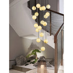 Tight view of the cascade in a bronze-railed stairwell, a candle lantern in the foreground.